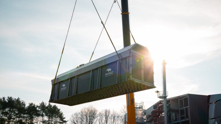 Container für Klärschlammtrocknung wird von einem Riesenkran auf der Baustelle der Schmidmeier NaturEnergie in Position gebracht