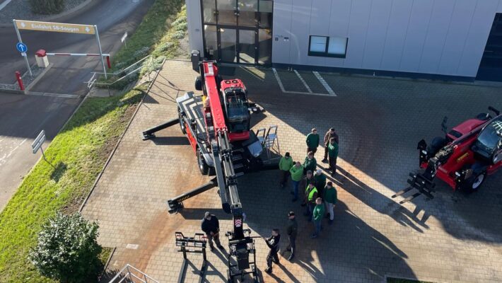 Vogelperspektive: Das Team der Schmidmeier NaturEnergie vor den Manitou Maschinen