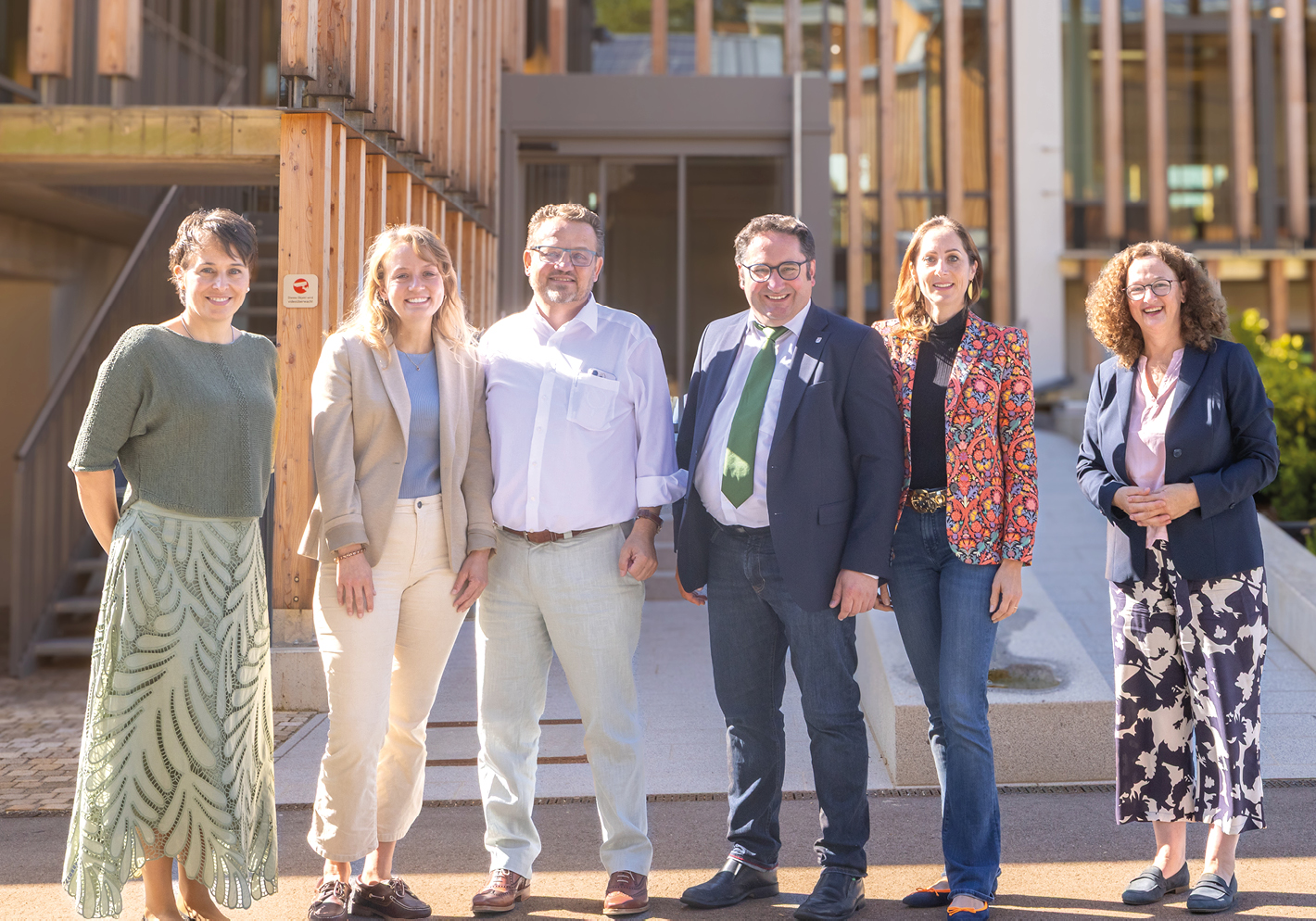 Politiker Tobias Gotthardt mit Thomas Schmidmeier und Mitarbeitern von Schmidmeier NaturEnergie vor Bürogebäude