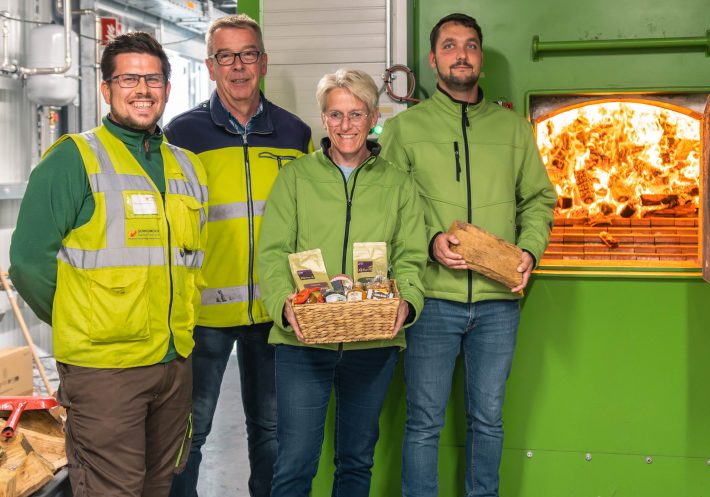 Mitarbeiter von Schmidmeier NaturEnergie und EGST vor Biomassekessel in Saerbeck
