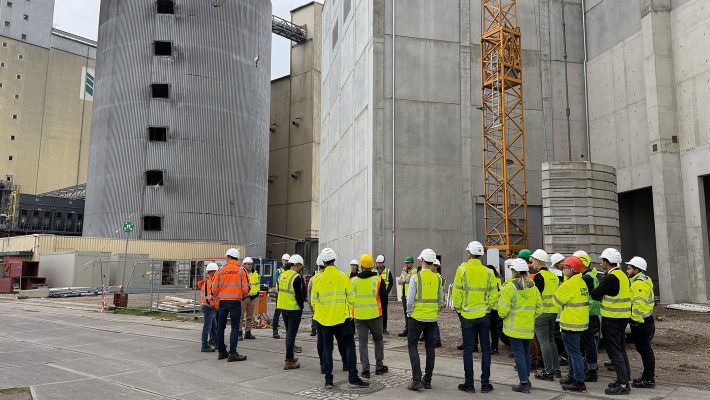 Personen-Gruppe in Warnwesten auf Baustelle.