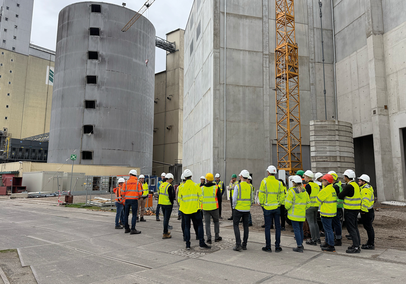 Personen-Gruppe in Warnwesten auf Baustelle.