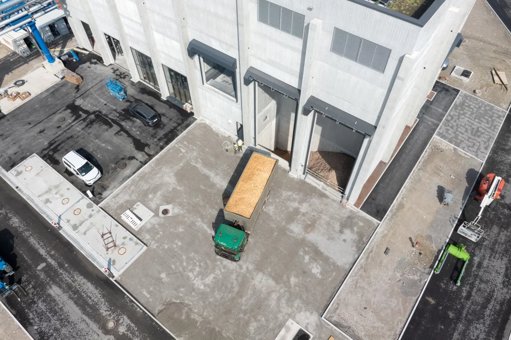 Waldrestholz wird bei Projekt Penzberg per LKW angeliefert und abgeladen.