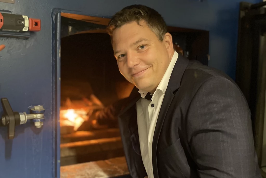 Geschäftsführer der Ofa Bamberg, Hr. Dr. Bohnen, bei der Anfeuerung der Biomasseanlage