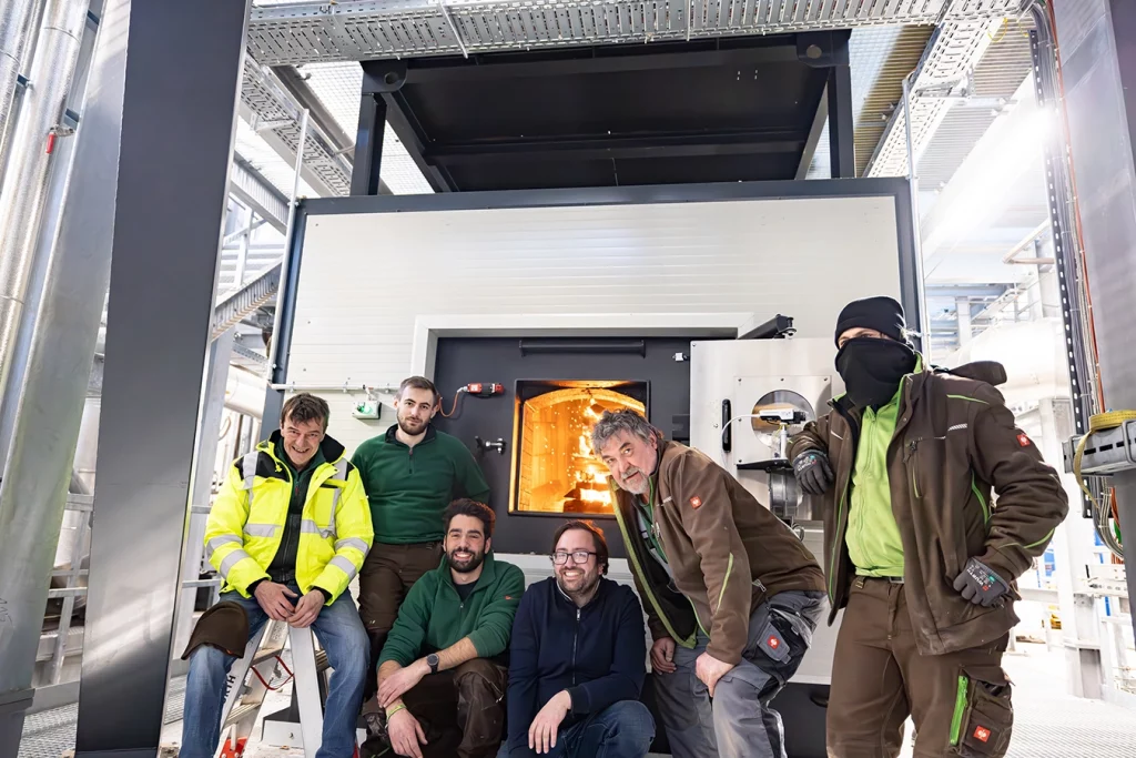 Mitarbeiter von Schmidmeier NaturEnergie GmbH vor Kessel einer Biomasseanlage in Feulersdorf