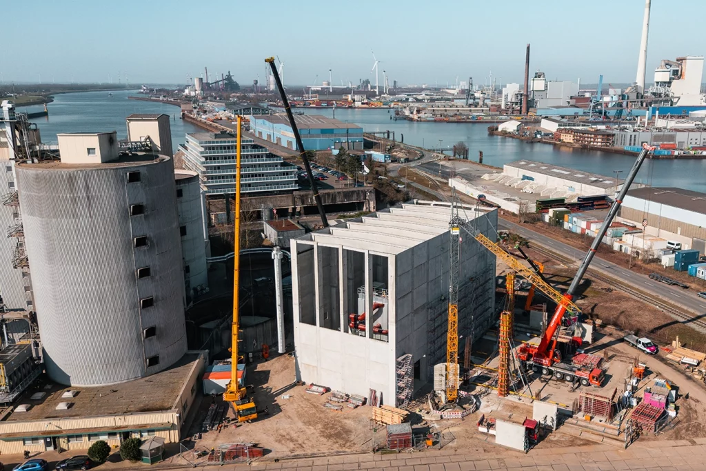 Drohnenaufnahme von einer Biomasseanlage im Hafen von Bremen für Avangard. Kräne, die Anlage, ein Schornstein und die danebenfließende Weser sind zu erkennen.