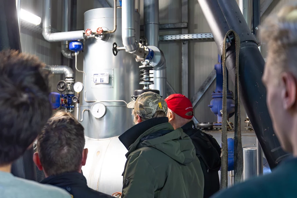 Teilnehmenden der DEKRA Kesselwärter Schulung schauen sich Kessel einer Biomasseanlage an.