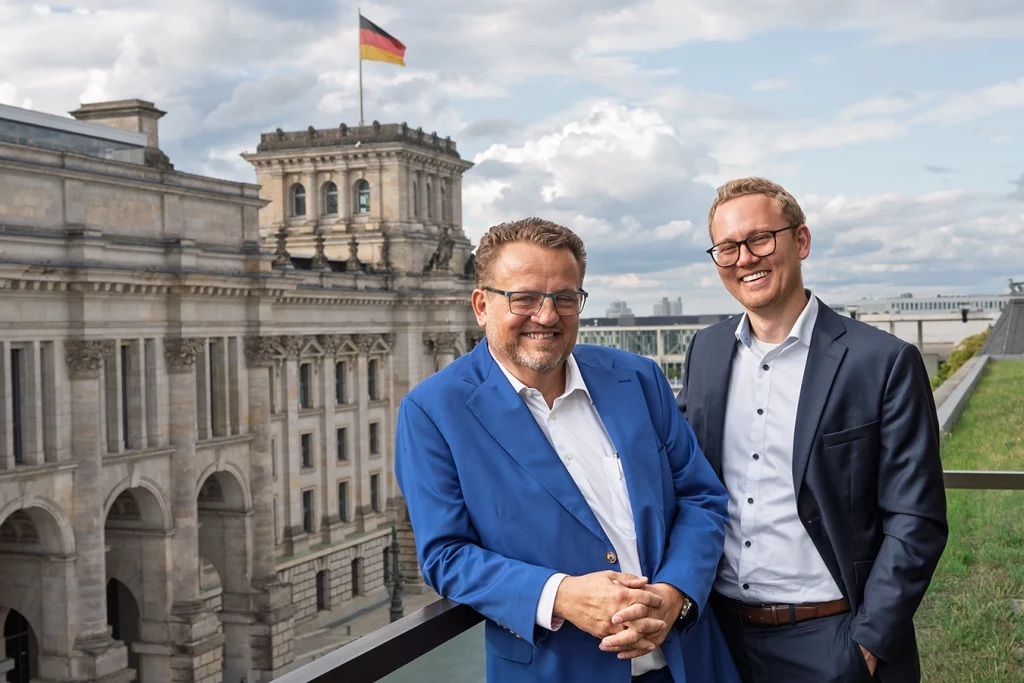 Thomas und Ferdinand Schmidmeier, Geschäftsführung der Schmidmeier NaturEnergie. Bundestag Berlin im Hintergrund.