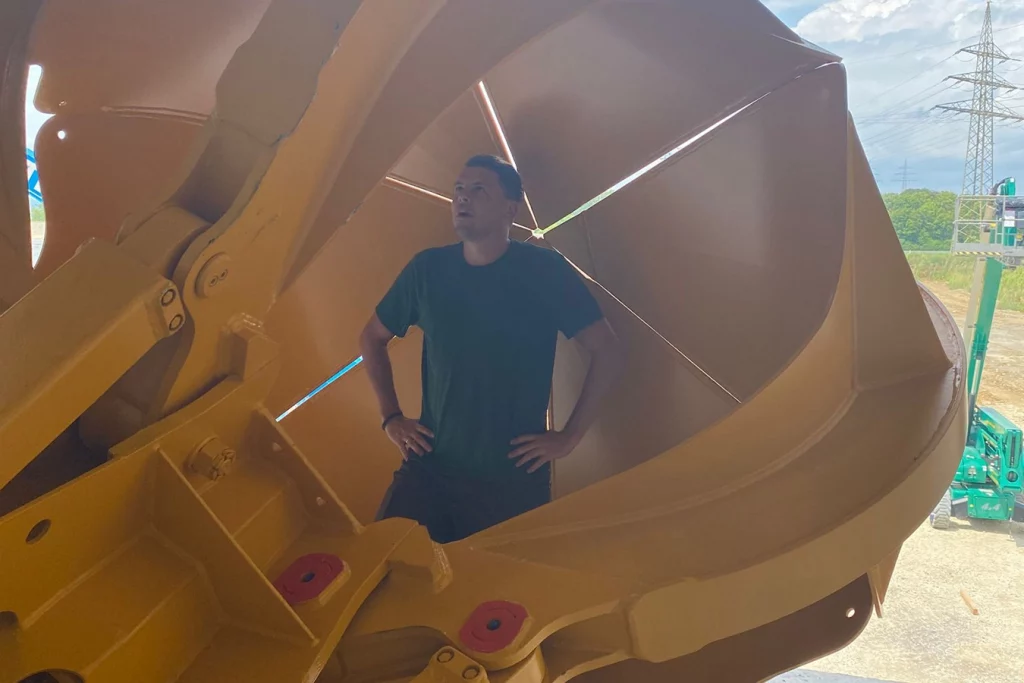 Mitarbeiter der Schmidmeier NaturEnergie steht in einer Komponente der Anlage