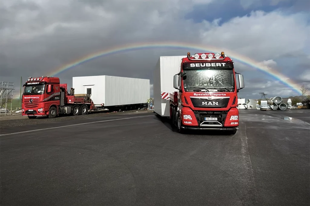 LKWs mit neuer Kesselanlage für die OFA in Bamberg. Am Himmel sieht man einen Regenbogen