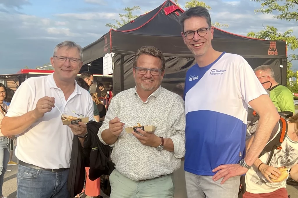 Thomas Schmidmeier mit zwei weiteren Personen beim Essen nach dem Firmenlauf der REWAG