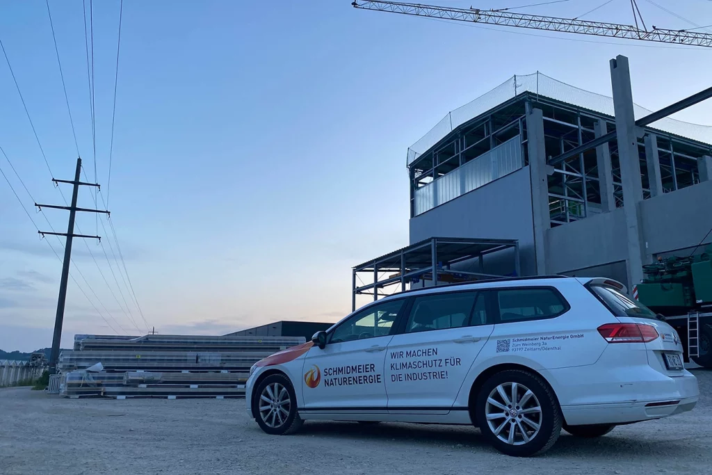 Firmenauto der Firma Schmidmeier NaturEnergie vor dem Gebäude der Biomasseanlage in Singen