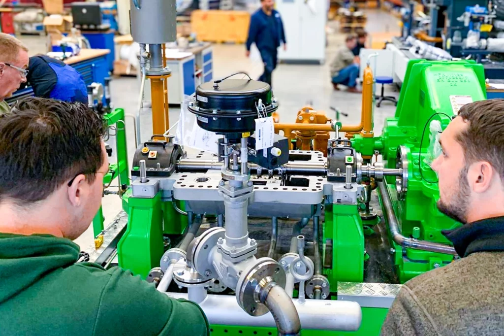Zwei Männer von hinten, die die Turbine für die Biomasseanlage von EGST in Saerbeck, betrachten