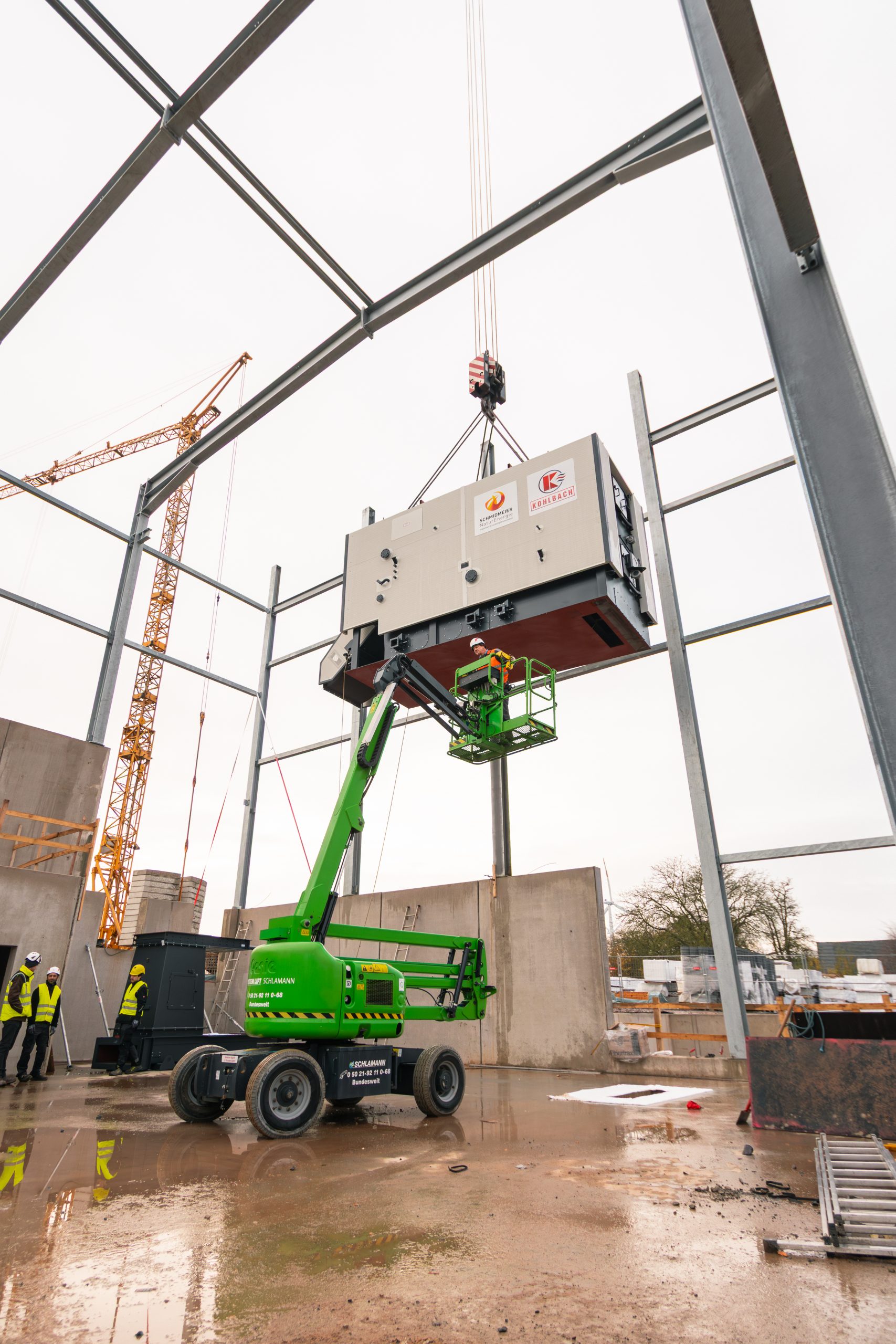 Kran und Mitarbeiter beim Baubeginn in Hüllhorst
