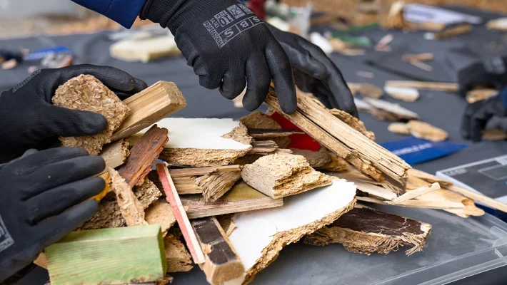 Zu sehen sind die Hände der Teilnehmenden , die die Alt-Holzschnitte zusammenlegen