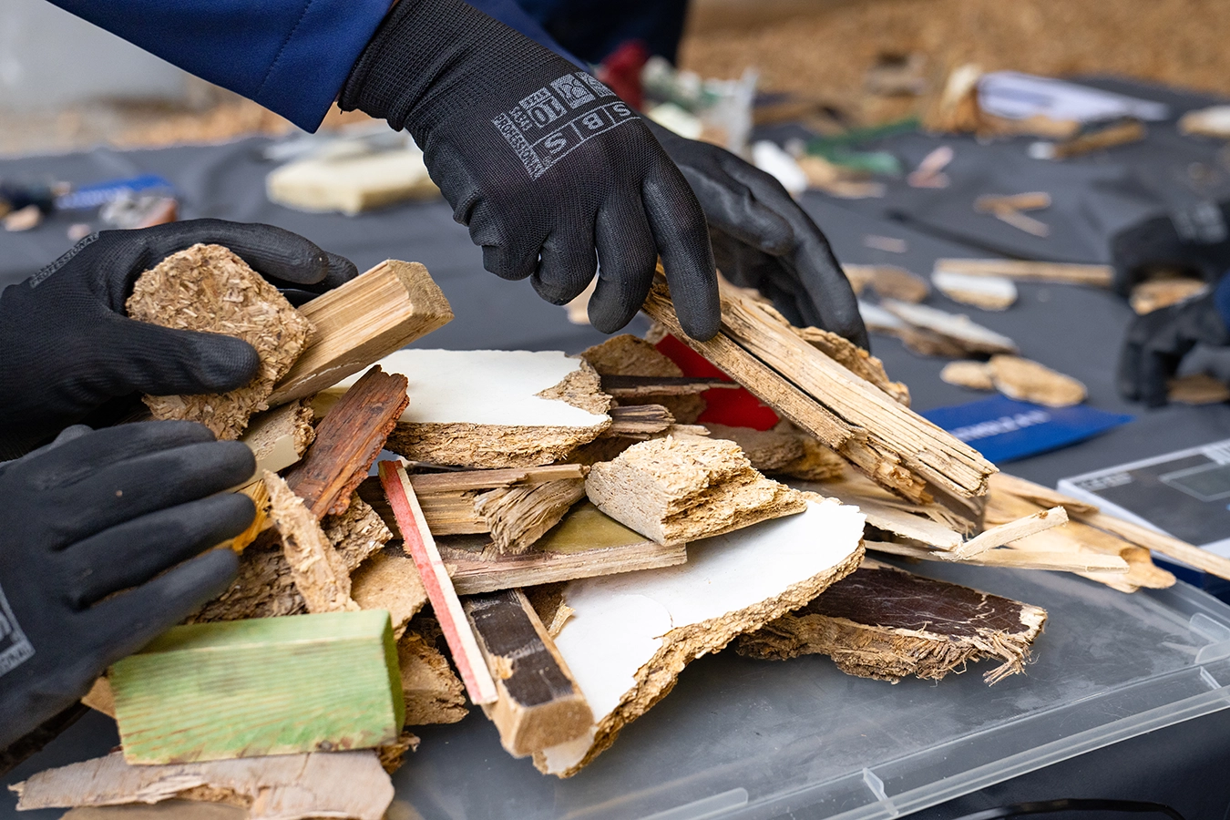 Zu sehen sind die Hände der Teilnehmenden , die die Alt-Holzschnitte zusammenlegen