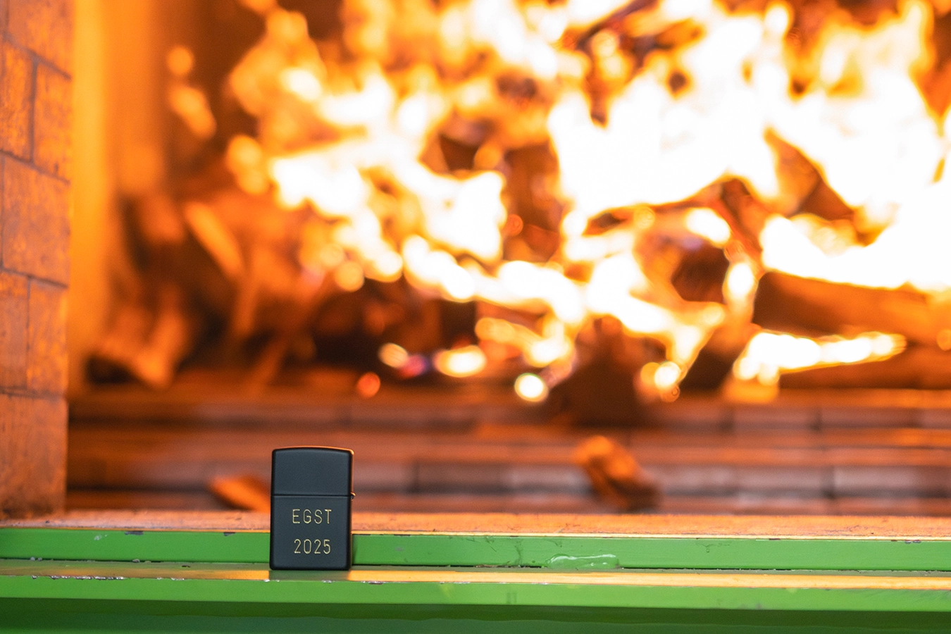 Brennender Kessel. Im Vordergrund steht ein Feuerzeug mit der Aufschrift "EGST 2025".