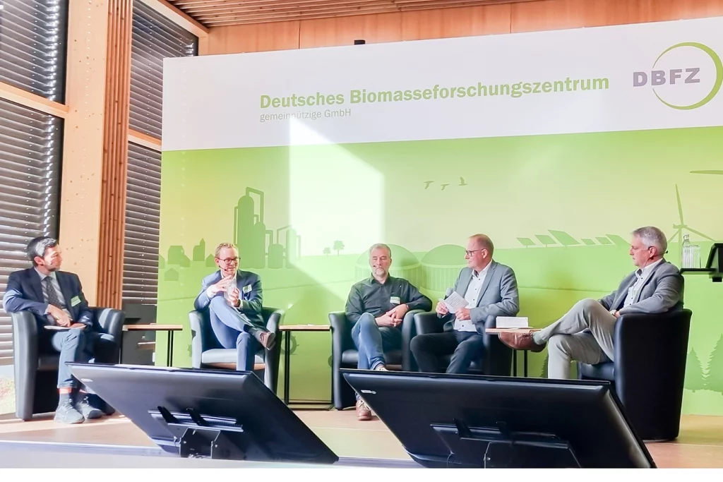 Fünf Personen, darunter Geschäftsführer Ferdinand Schmidmeier, diskutieren beim Fachgespräch „Hybride Wärmebereitstellung mit Bioenergie“ im Deutschen Biomasseforschungszentrum (DBFZ) in Leipzig.