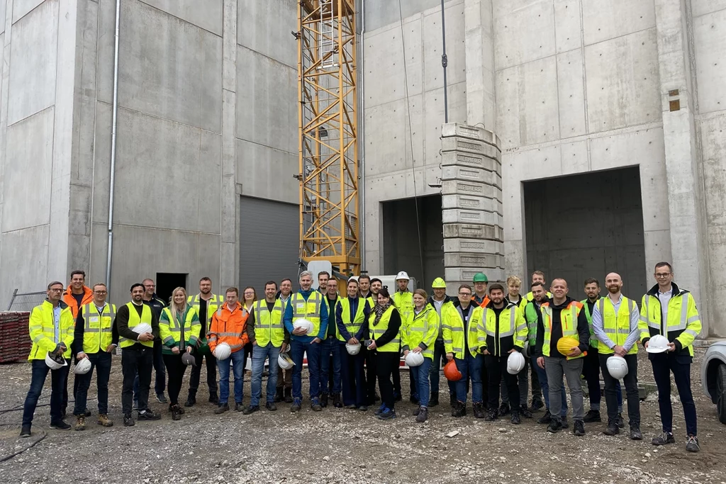Gruppenbild der Jungen Gruppe und der Mitarbeiter von Schmidmeier NaturEnergie vor der Biomasseanlage in Bremen.