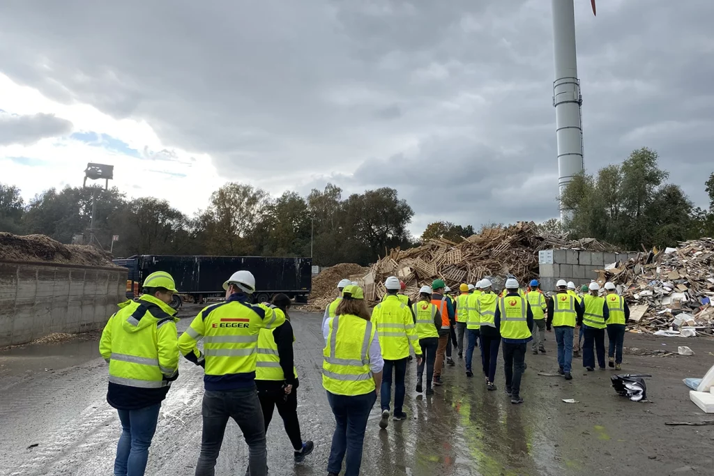 Die Junge Gruppe besichtigt die Biomasseanlage in Bremen. Sie sind draußen und tragen alle Warnwesten.