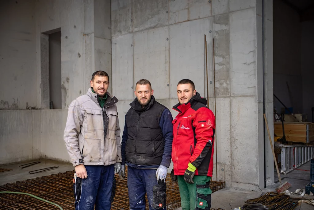 Gruppenbild mit drei Mitarbeitern der Schmidmeier NaturEnergie vor der Werkstatt