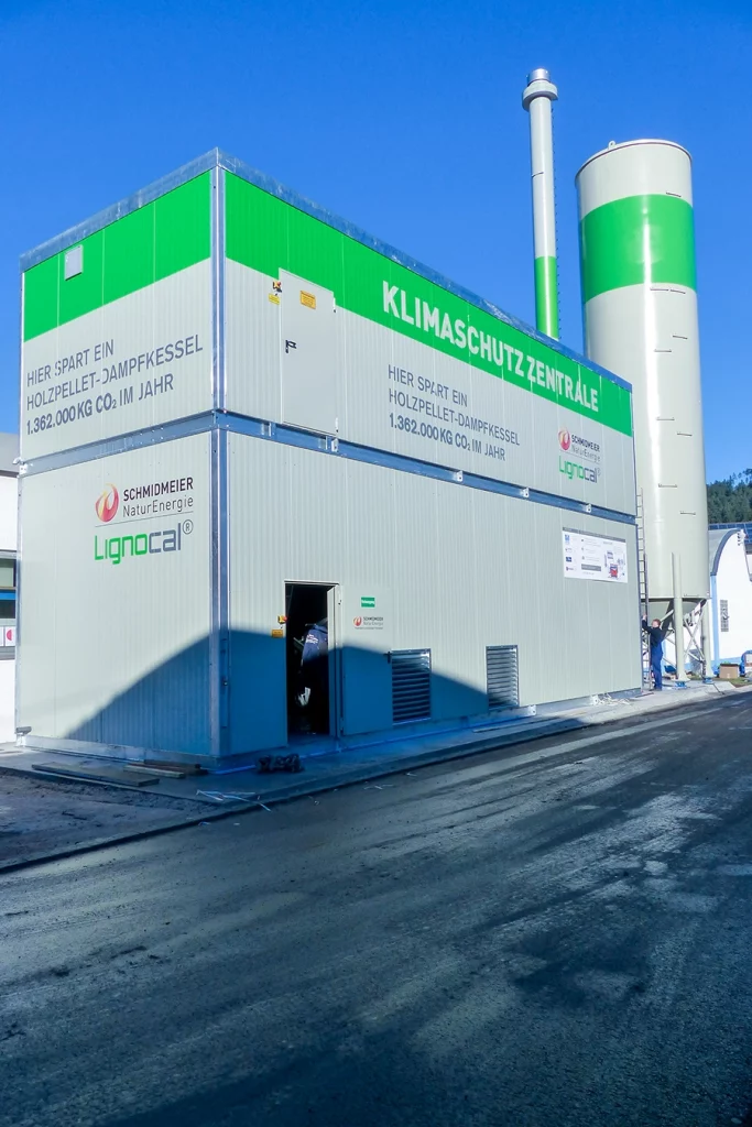 Graue Biomasse-Dampfanlage in Baiersbronn mit grünen Elementen.