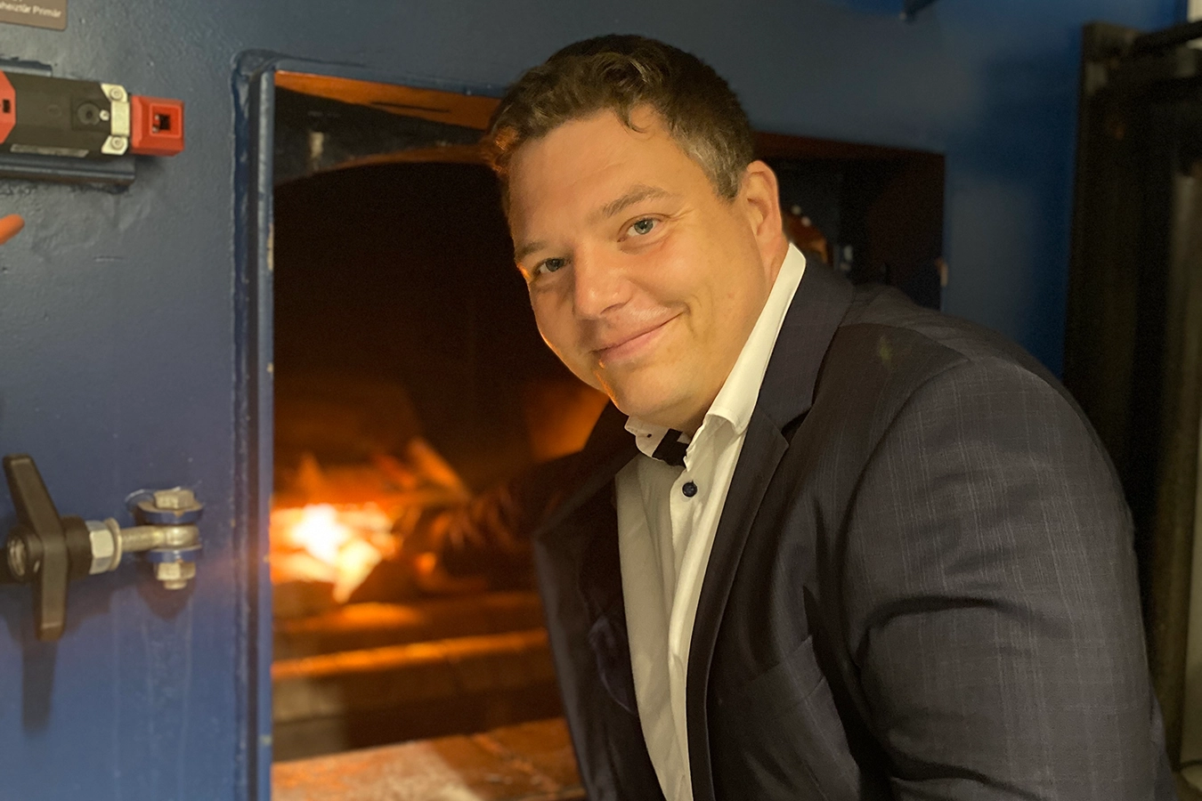 Geschäftsführer der Ofa Bamberg GmbH Dr. Fabian Bohnen streckt seinen Arm in einen Ofen