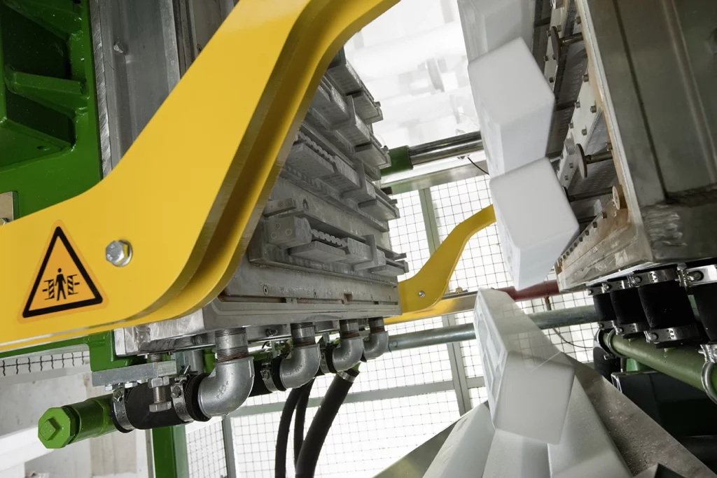 Maschine stellt weiße Formteile her.