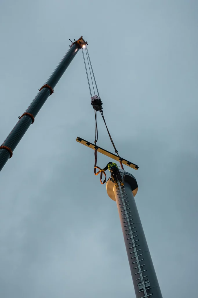 Kran transportiert Kamin einer Biomasseanlage.