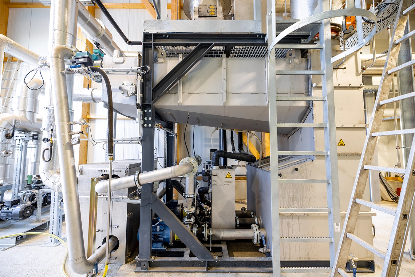 Rauchgaskondensation eines Biomassekessels in Kirchheim. Viele Rohre aus Metall, die miteinander verzweigt sind.