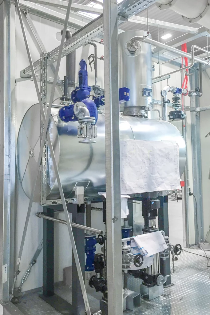 Biomassebefeuerte Dampfanlage von innen. Metallkonstruktionen mit Rohren.