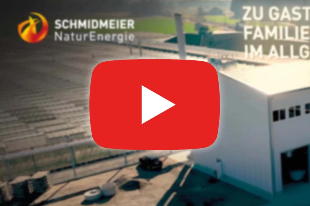 YouTube Play-Button vor Thumbnail eines Videos von der Schmidmeier NaturEnergie. Auf dem Thumbnail ist eine Biomasseanlage aus Vogelperspektive abgebildet.