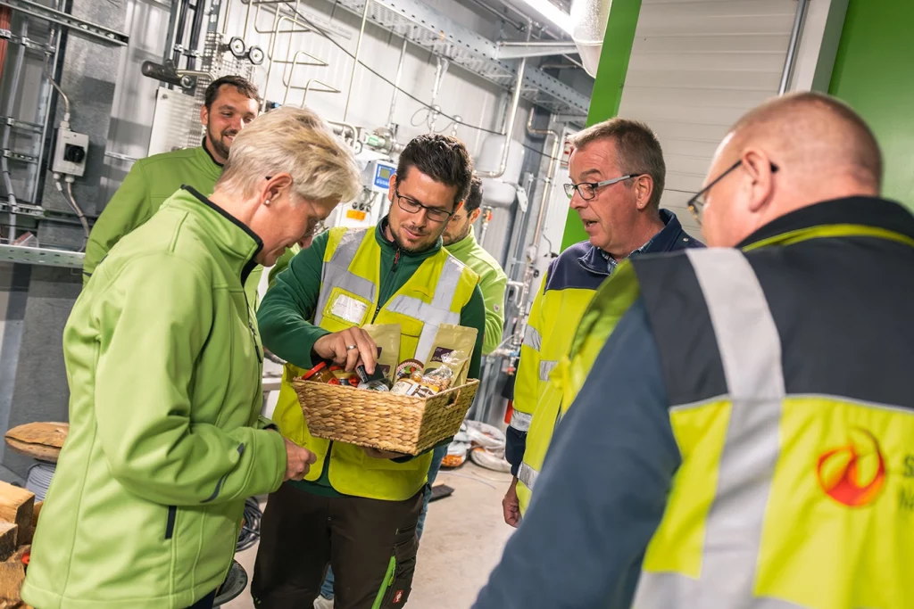 Übergabe eines Geschenkkorbs an die Mitarbeiter der EGST durch Martin Goldbach, Mitarbeiter der Schmidmeier NaturEnergie.