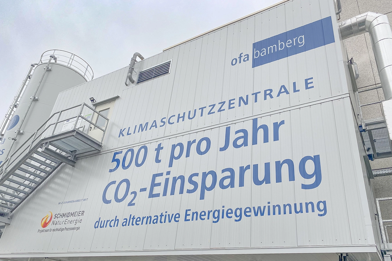 Banner mit Informationen zur CO2 Einsparung auf der Fassade des Gebäudes der Anlage
