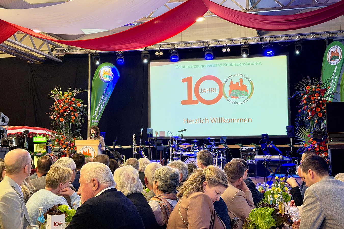 Gäste im Festungssaal und Leinwand mit 100 Jahre Jubiläum Aufschrift
