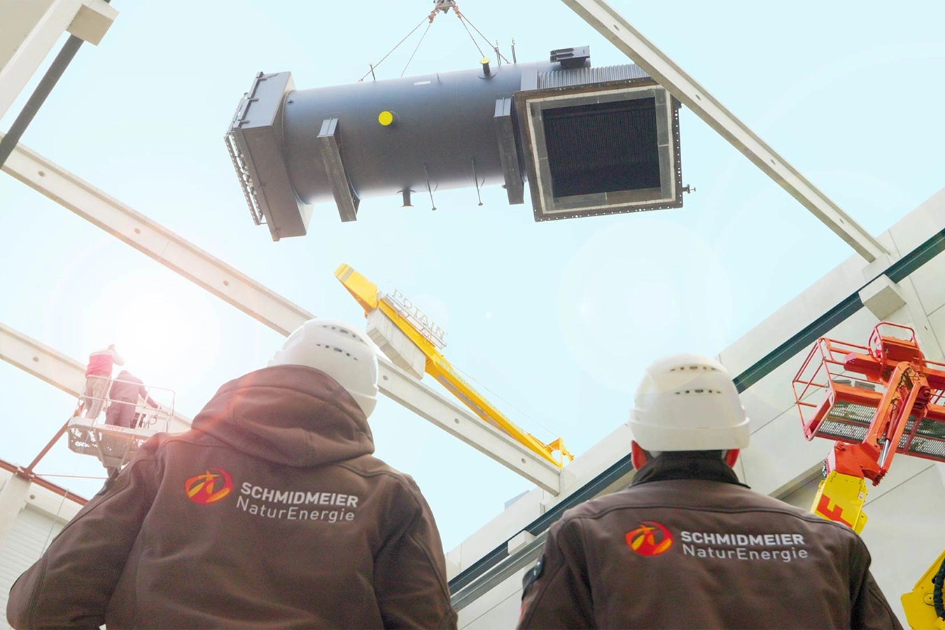 Zwei Mitarbeiter der Schmidmeier NaturEnergie überwachen die Fortschritte auf einer Baustelle