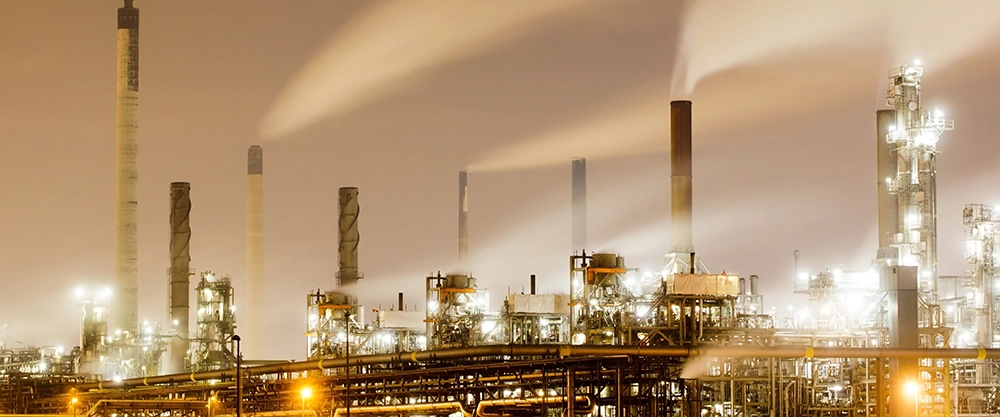 Kamine eines Industrieparks in der Dämmerung