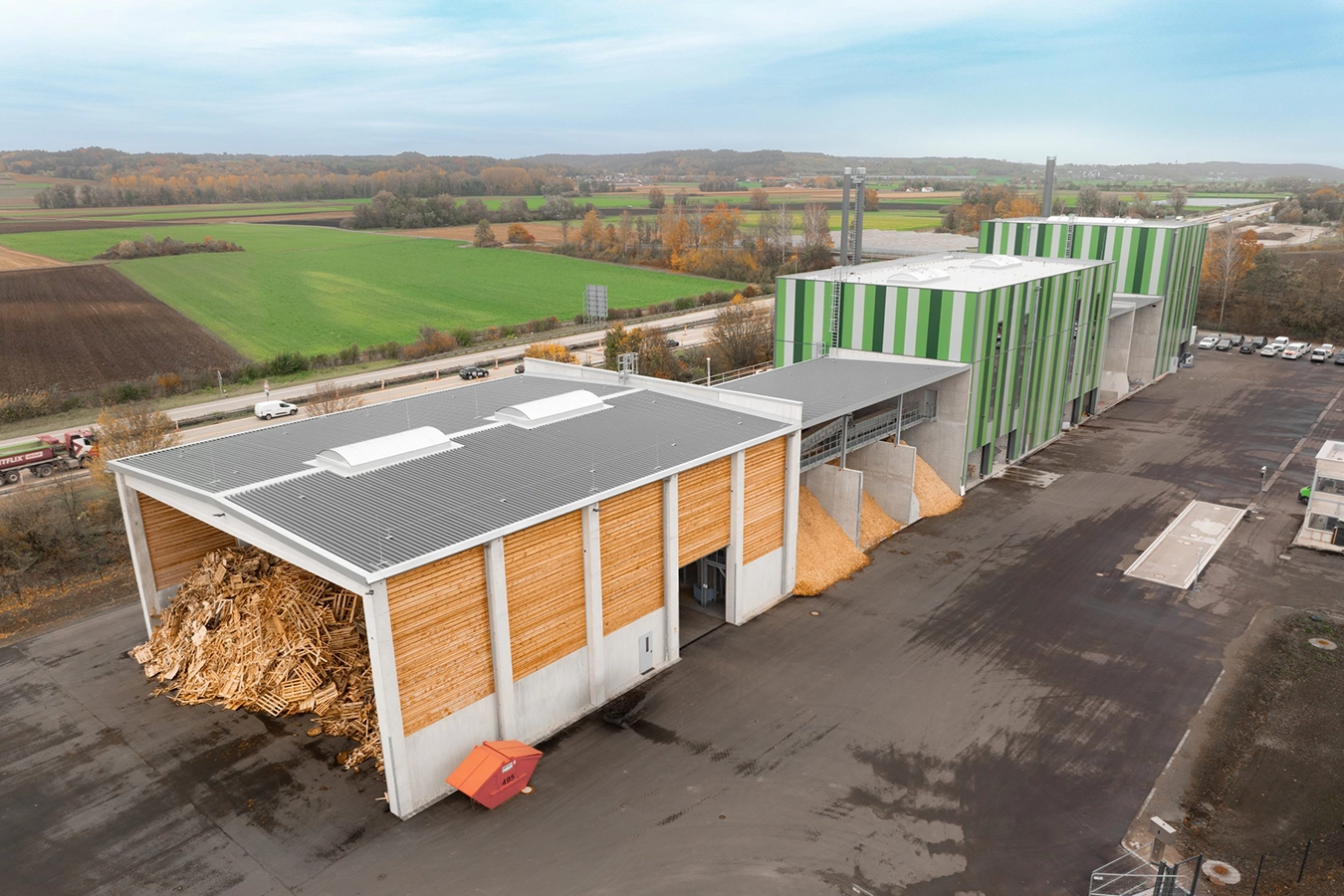 Ansicht der Anlage mit Pellets und Holzschnitte von außen.