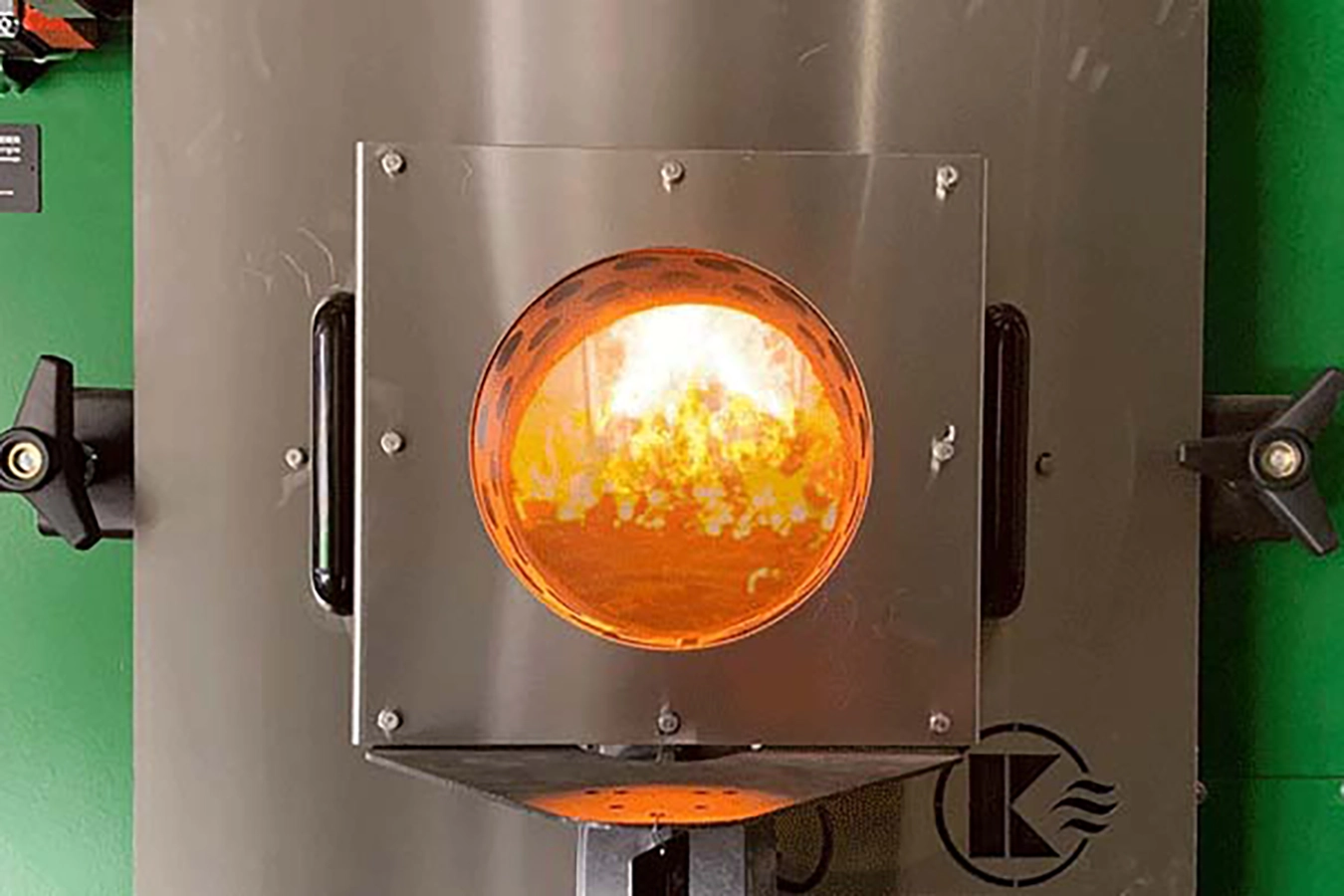 Ansicht des Feuerraums/Feuerbox mit brennendem Feuer von außen.