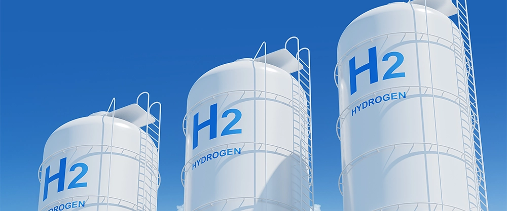 Drei weiße H2-Tanks (Wasserstoff) vor blauem Himmel