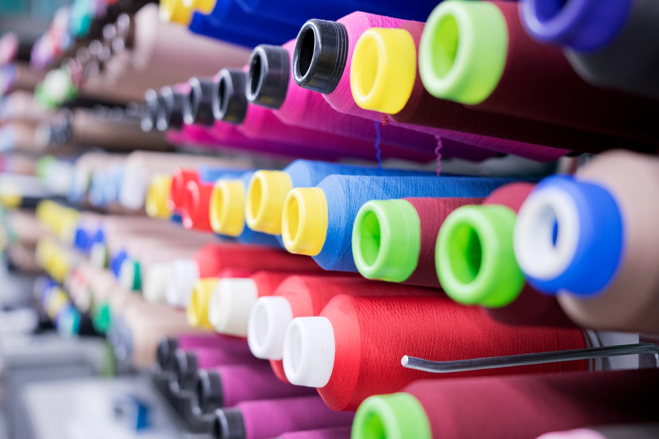 Nahaufnahme von geordneten Nähspulen mit verschiedenen Farben.