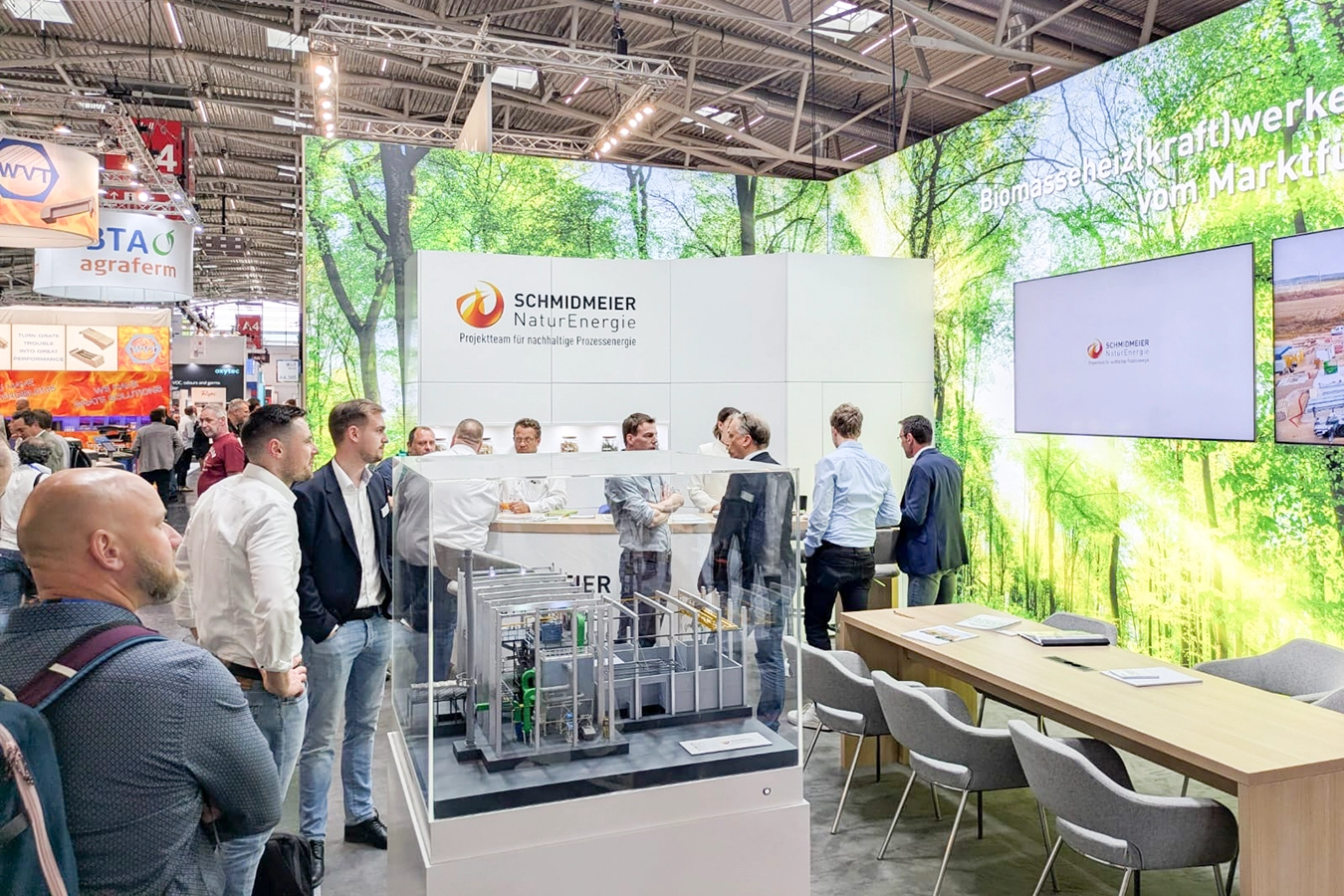 Mitarbeiter von Schmidmeier NaturEnergie auf der IFAT München. in aktiven Gesprächen mit Messebesucher:innen